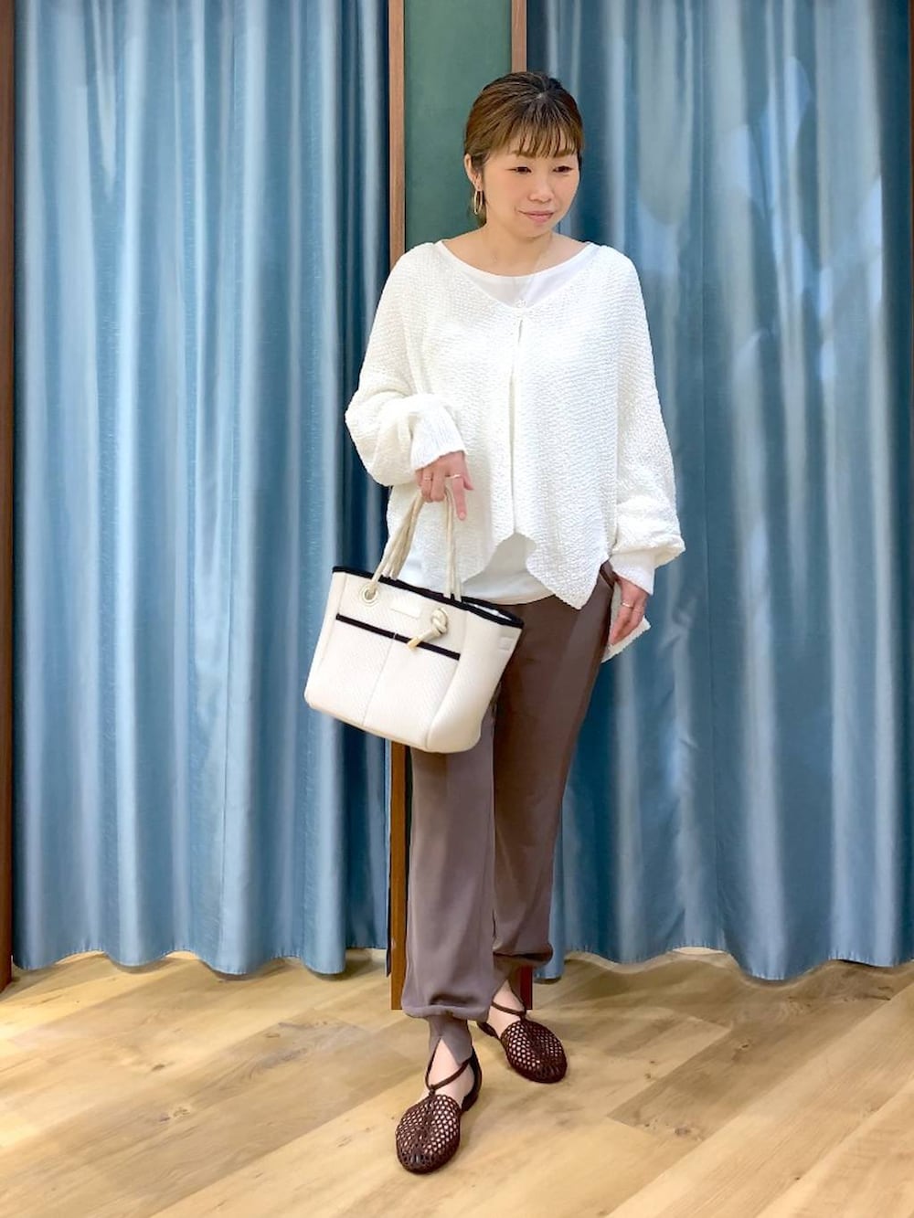 ホワイト系のTシャツ/カットソー、ホワイト系のカーディガン/ボレロ、ブラウン系のスリッポンを着用したレディースの春コーディネートの3枚目の写真
