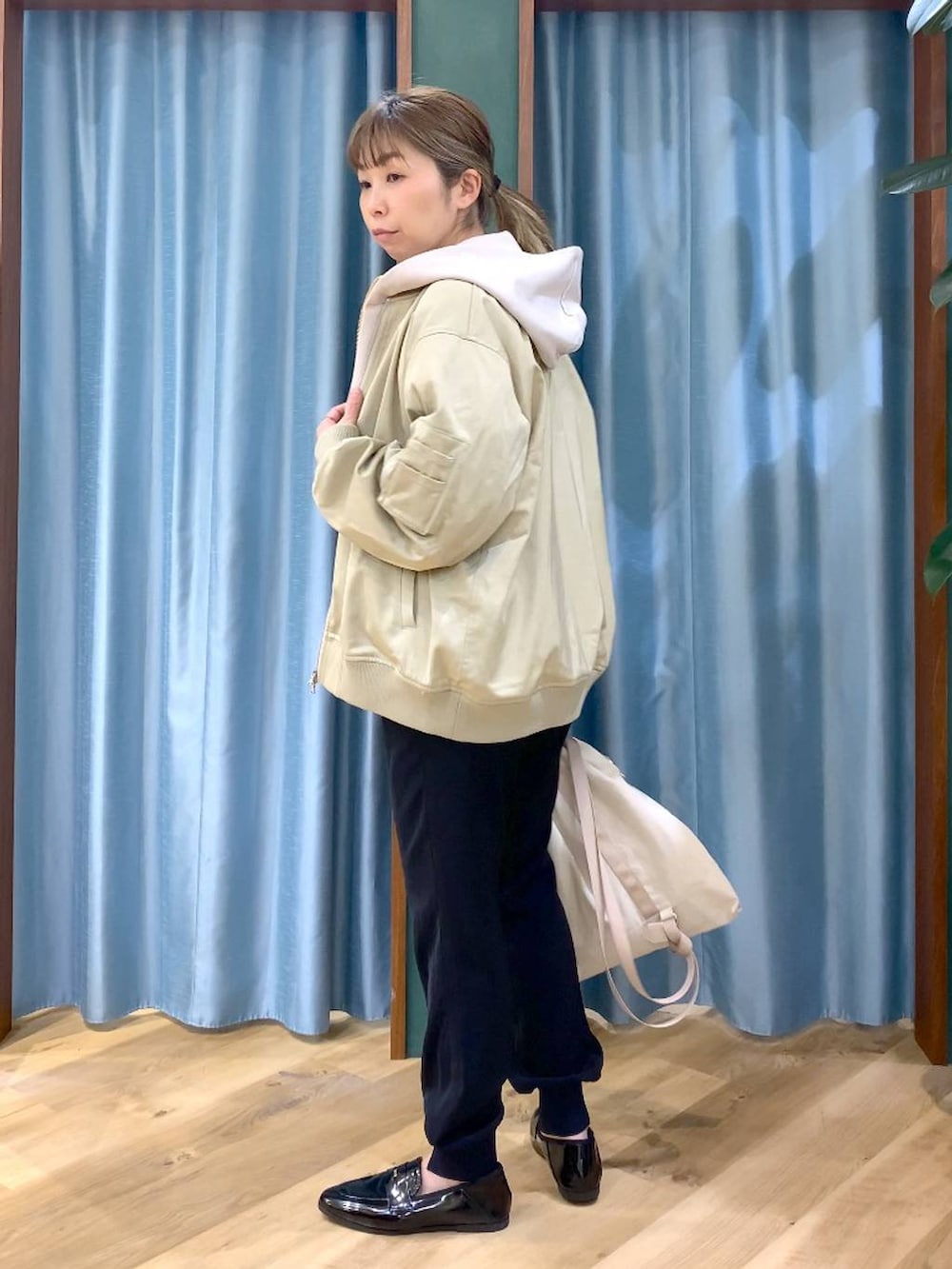 ベージュ系のパーカー、グリーン系のMA-1、ホワイト系のTシャツ/カットソーを着用したレディースの冬コーディネートの4枚目の写真