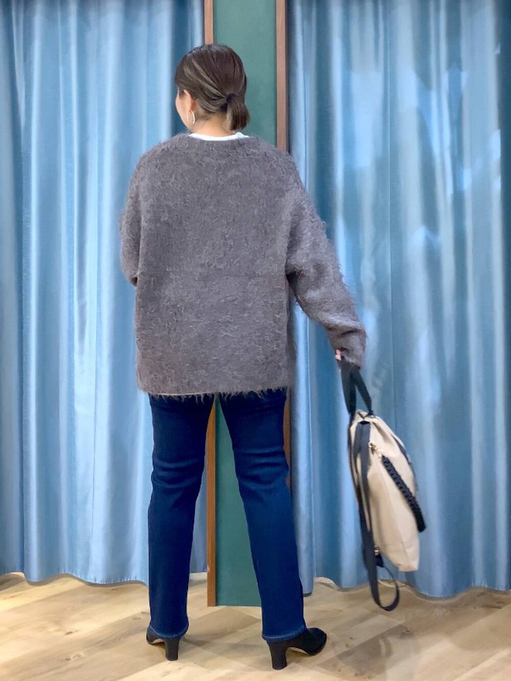 ブルー系のデニムパンツ、ブラック系のブーツ、ホワイト系のTシャツ/カットソーを着用したレディースの秋コーディネートの4枚目の写真