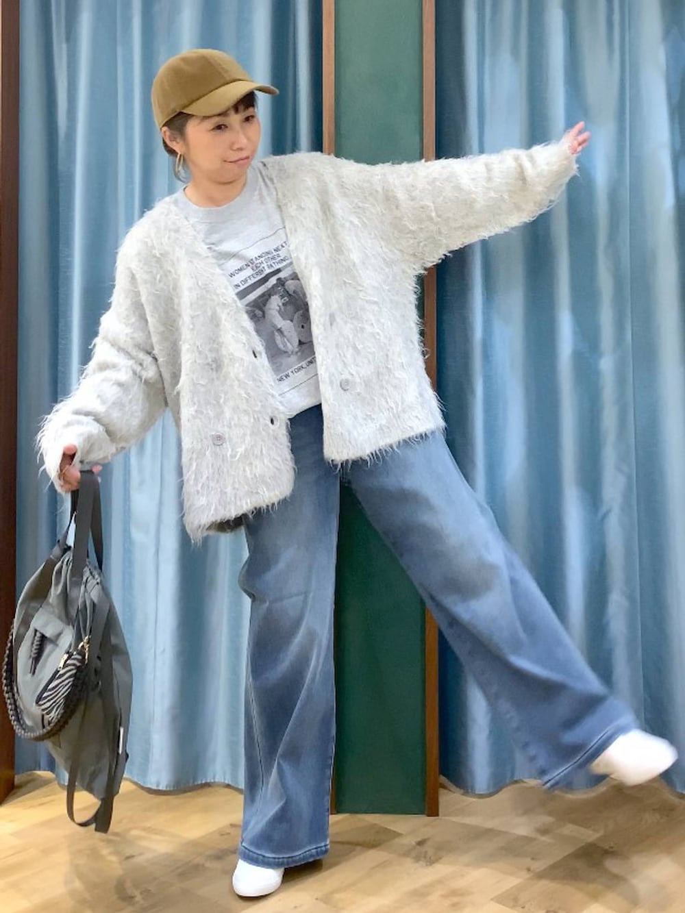 ブルー系のデニムパンツ、グレー系のTシャツ/カットソー、グレー系のバックパック/リュックを着用したレディースの秋コーディネートの3枚目の写真