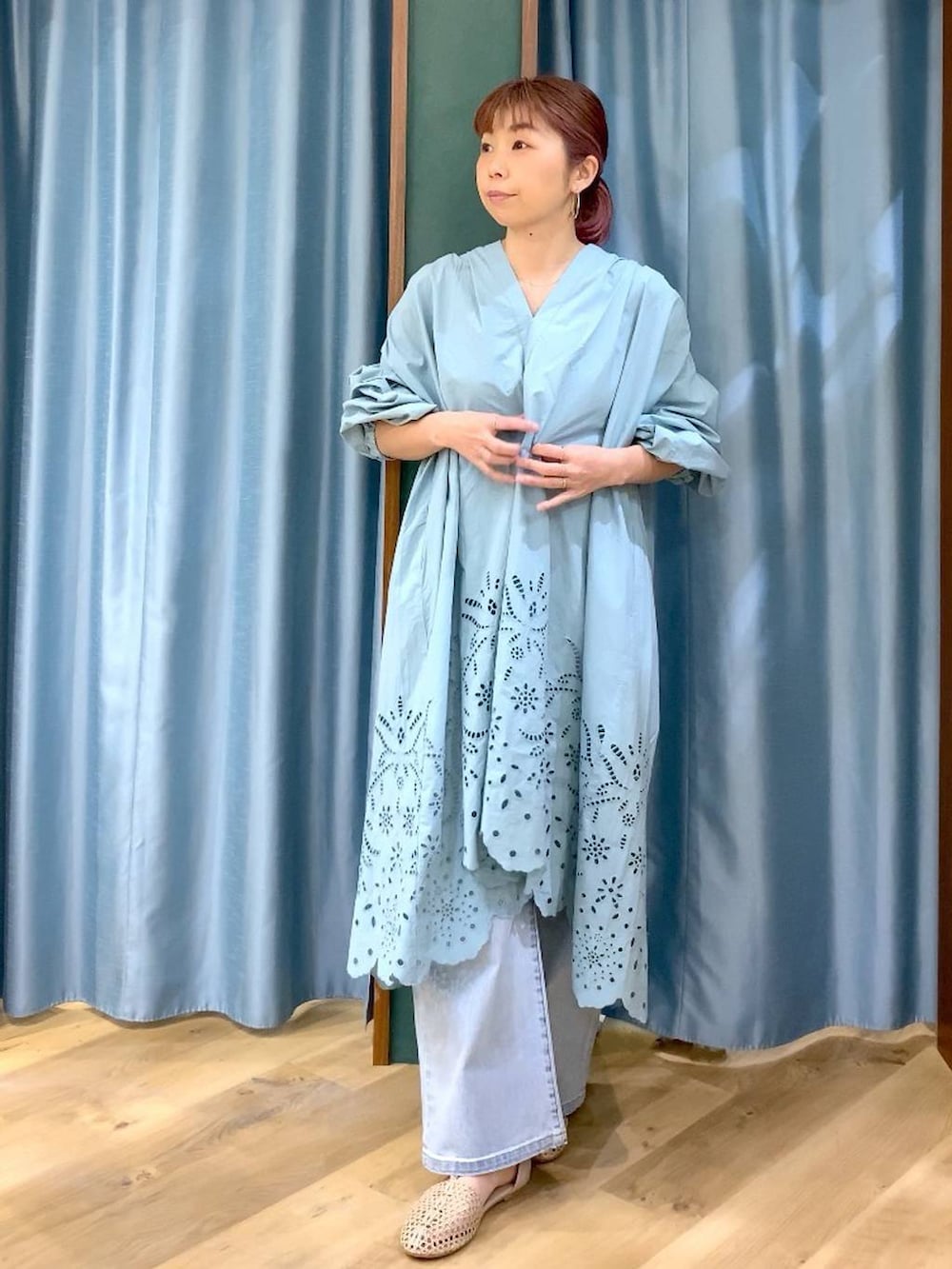 ブルー系のデニムパンツ、ベージュ系のスリッポン、グリーン系のワンピースを着用したレディースの春コーディネートの2枚目の写真