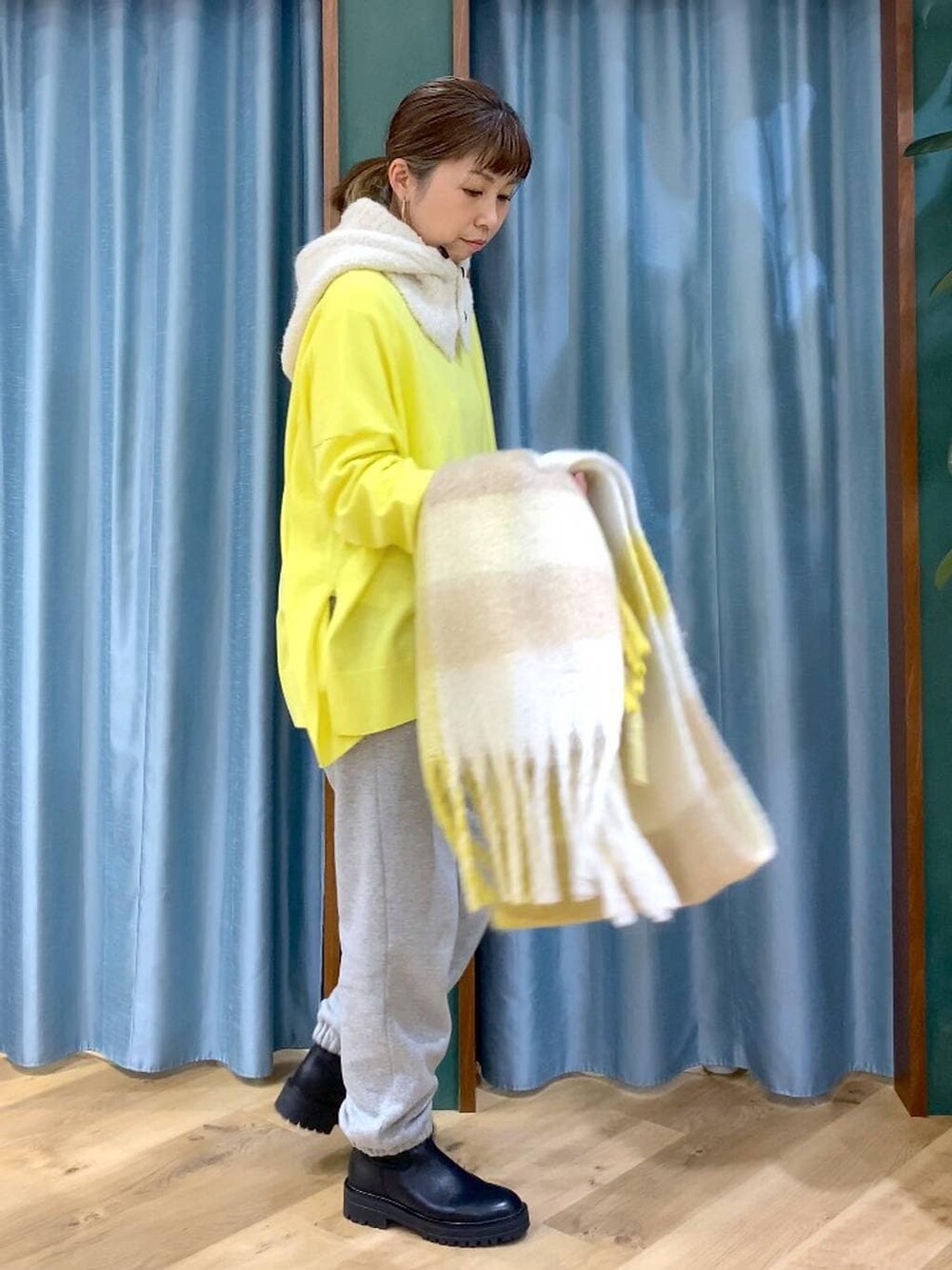 ブラック系のブーツ、ホワイト系のTシャツ/カットソー、イエロー系のニット/セーターを着用したレディースの秋コーディネートの3枚目の写真