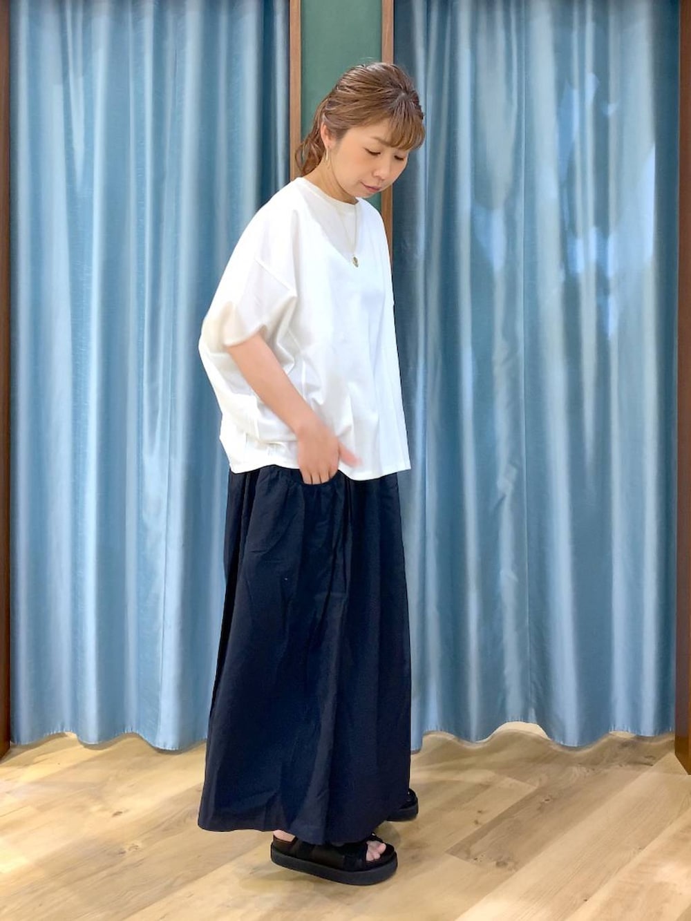 ホワイト系のTシャツ/カットソー、ブラック系のスカート、ブラック系のサンダルを着用したレディースの春コーディネートの4枚目の写真