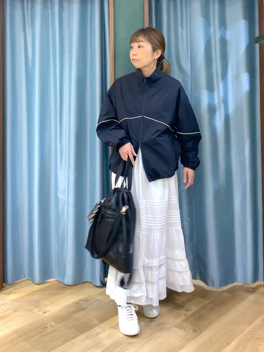 ブラック系のバックパック/リュック、ブルー系のナイロンジャケット、ブラウン系のスニーカーを着用したレディースの冬コーディネートの3枚目の写真