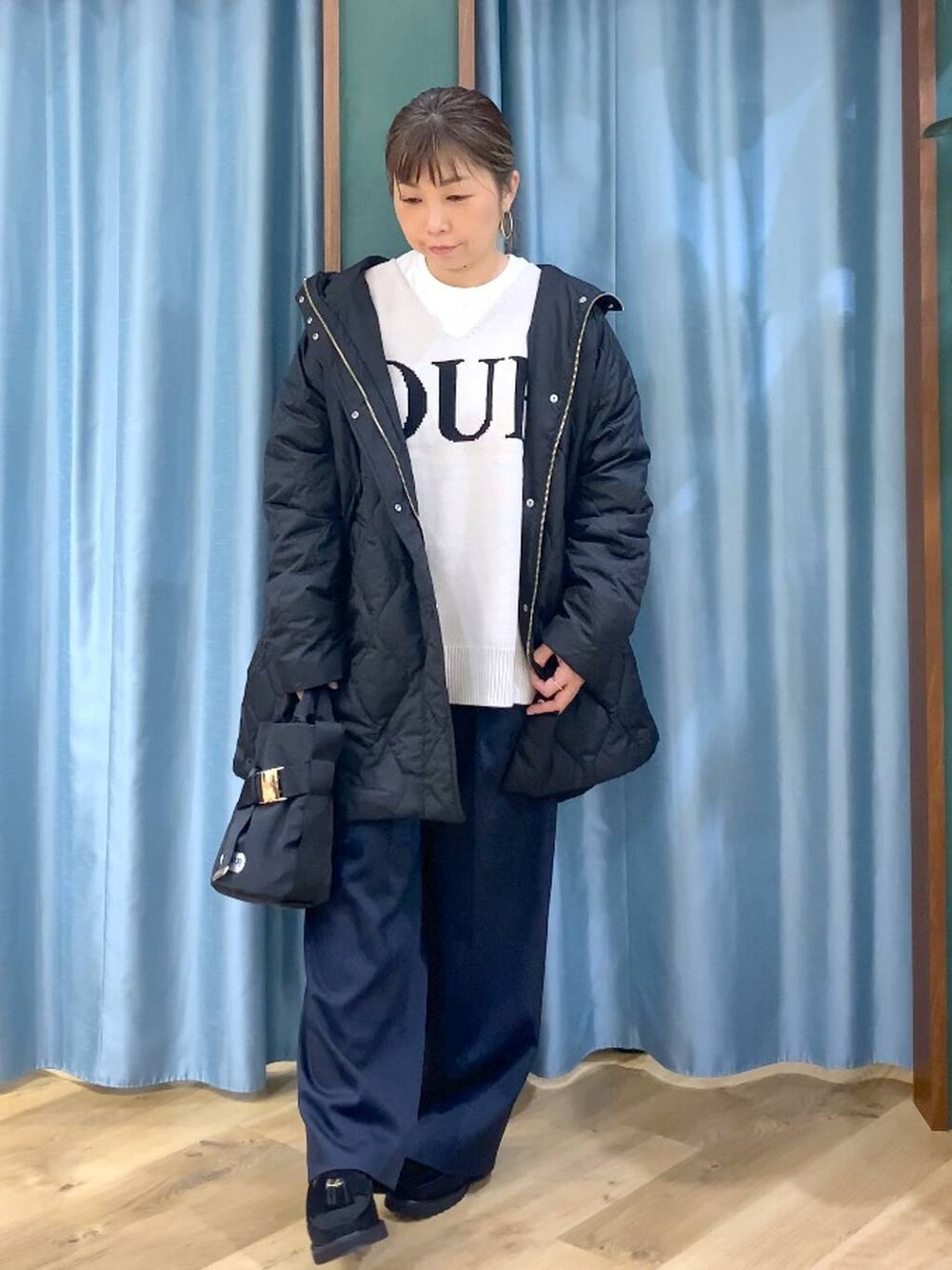 ベージュ系のニット/セーター、ブラック系のブルゾン、ブラック系のローファーを着用したレディースの秋コーディネートの6枚目の写真