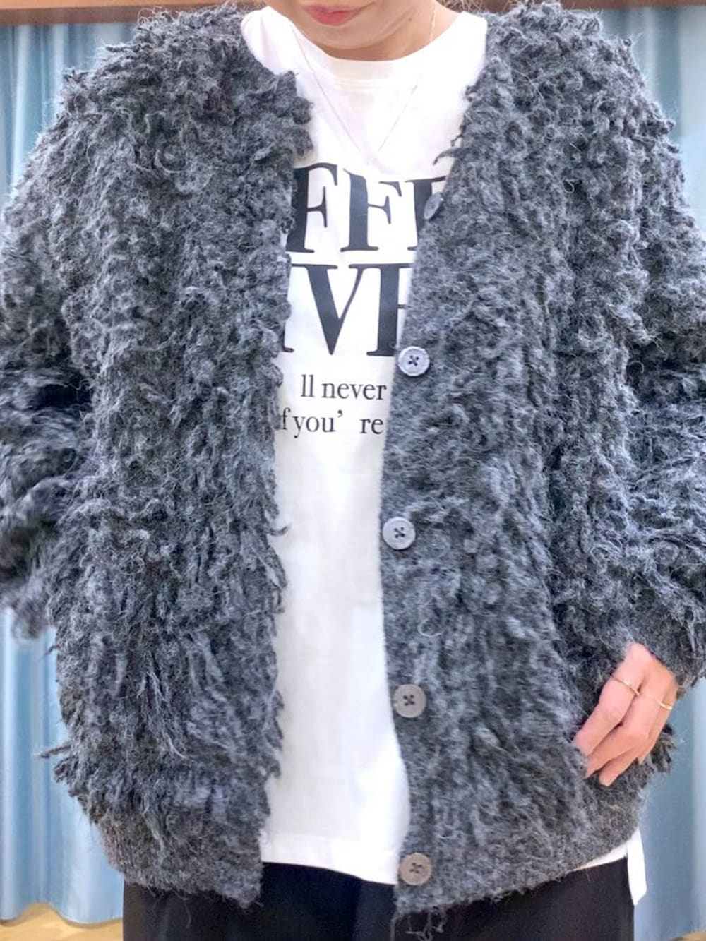 ブラック系のブーツ、ブラック系のスラックス、グレー系のカーディガン/ボレロを着用したレディースの冬コーディネートの8枚目の写真