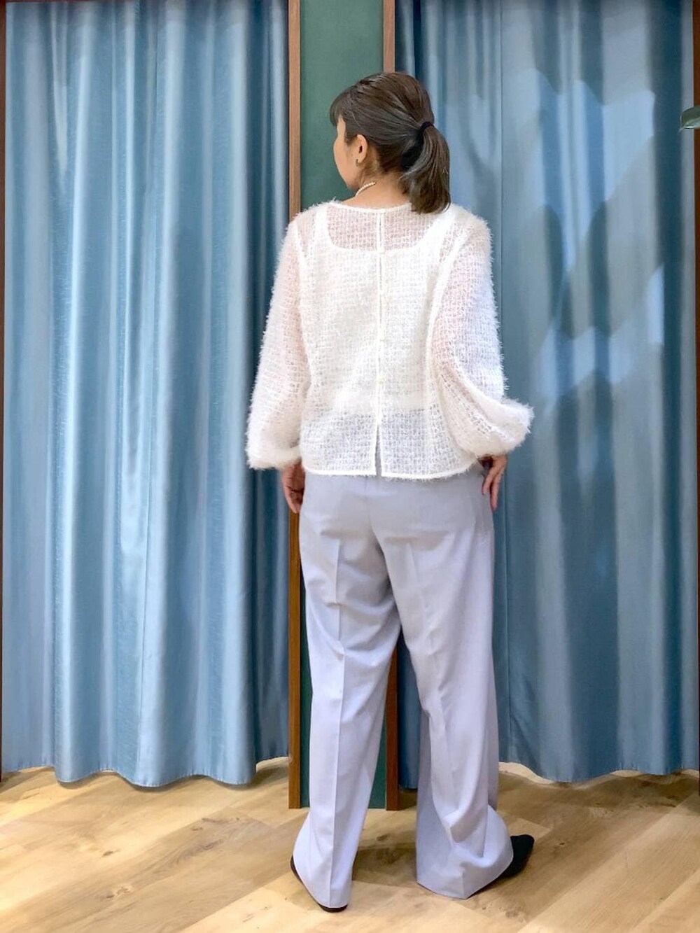 ホワイト系のタンクトップ、グレー系のその他パンツ、ベージュ系のステンカラーコートを着用したレディースの冬コーディネートの6枚目の写真