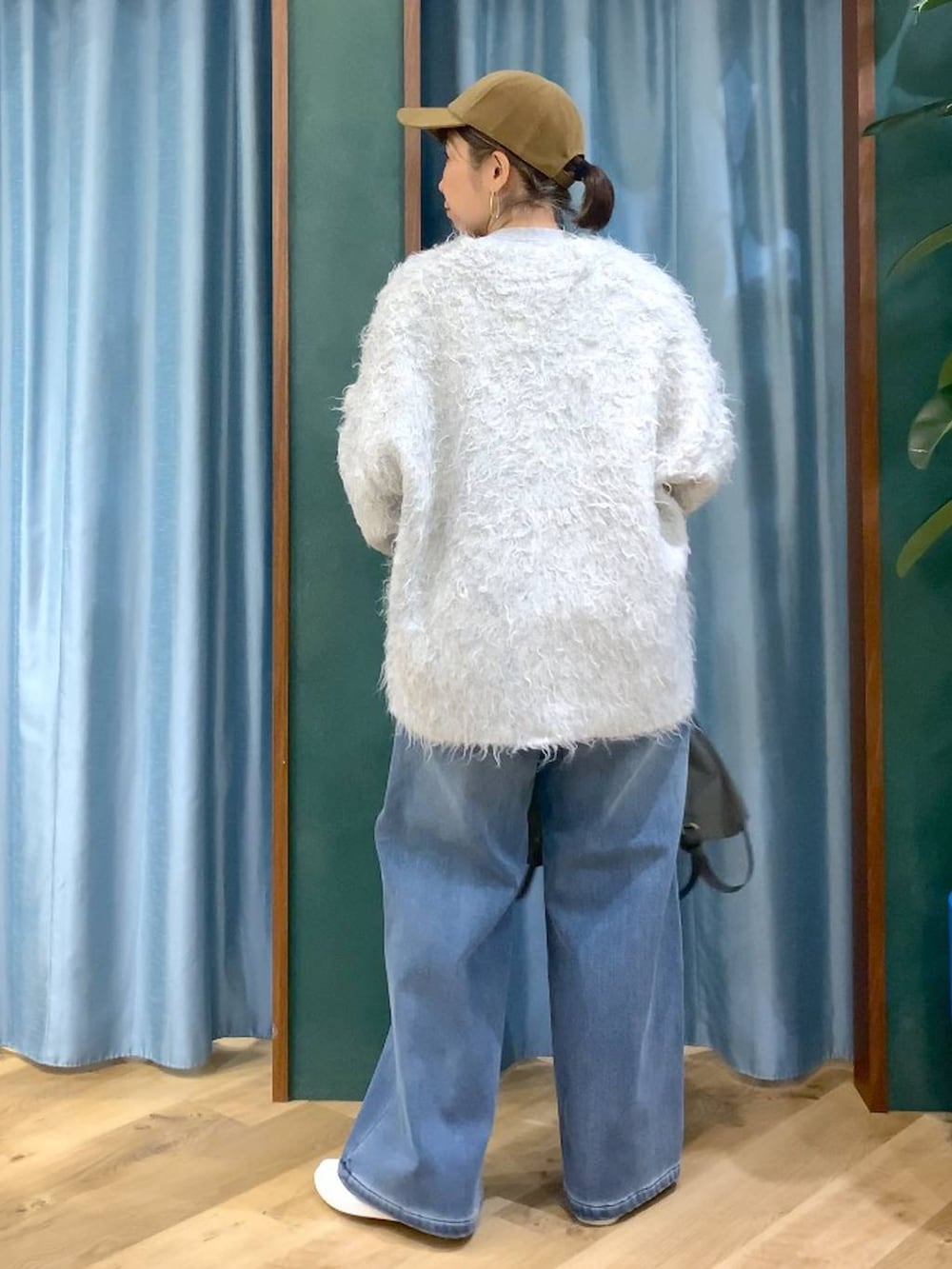 ブルー系のデニムパンツ、グレー系のTシャツ/カットソー、グレー系のバックパック/リュックを着用したレディースの秋コーディネートの5枚目の写真