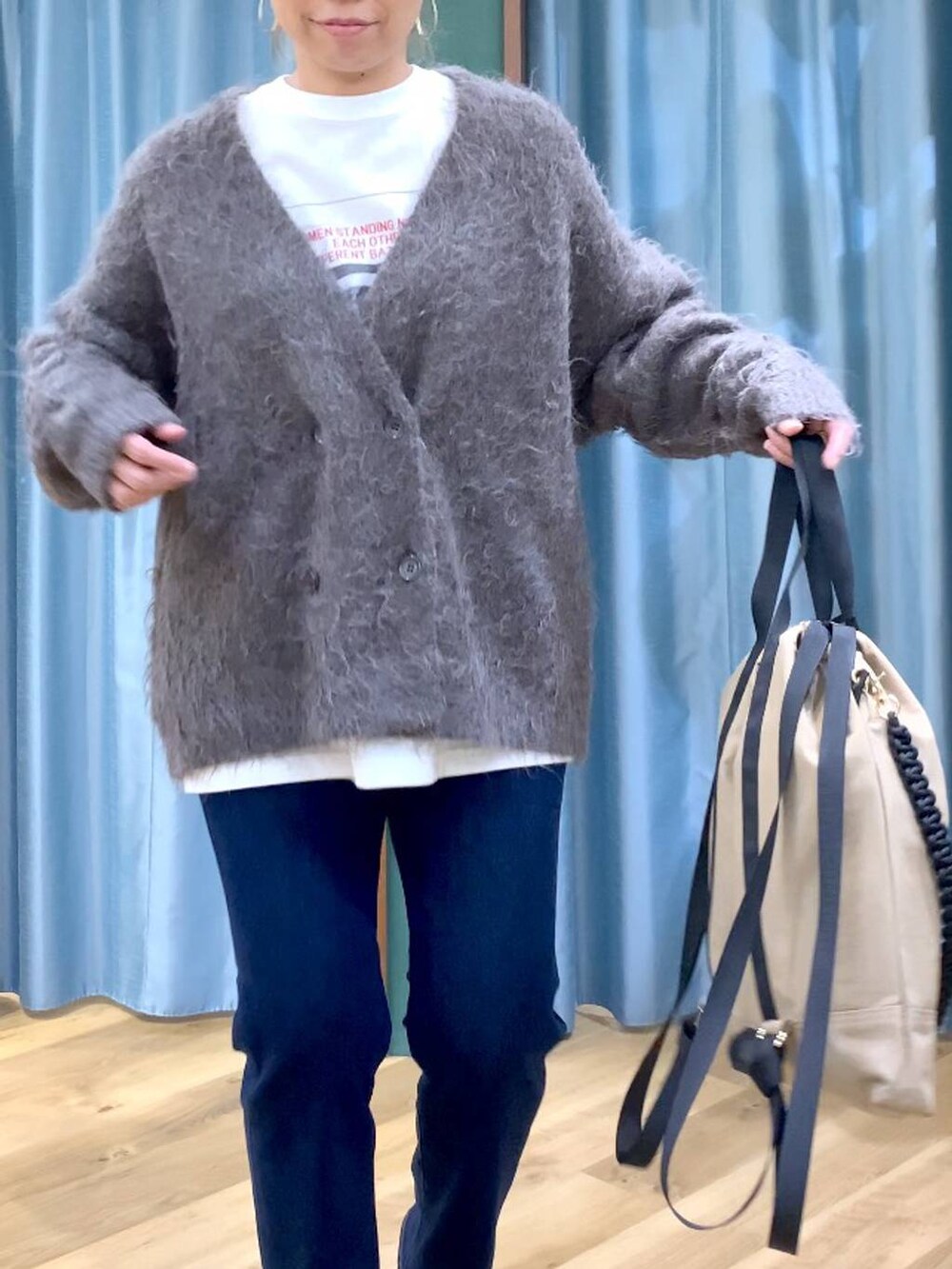 ブルー系のデニムパンツ、ブラック系のブーツ、ホワイト系のTシャツ/カットソーを着用したレディースの秋コーディネートの5枚目の写真