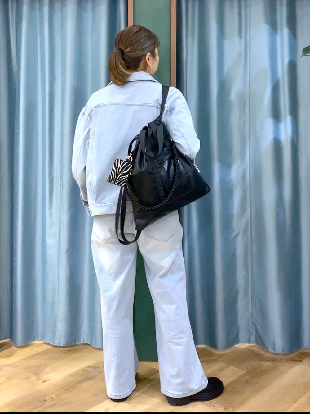 ブラック系のブーツ、ブラック系のバックパック/リュック、ブルー系のデニムパンツを着用したレディースの冬コーディネートの5枚目の写真