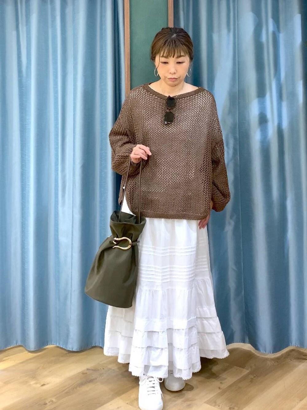 ブラウン系のスニーカー、ブラウン系のニット/セーター、ホワイト系のスカートを着用したレディースの冬コーディネートの4枚目の写真