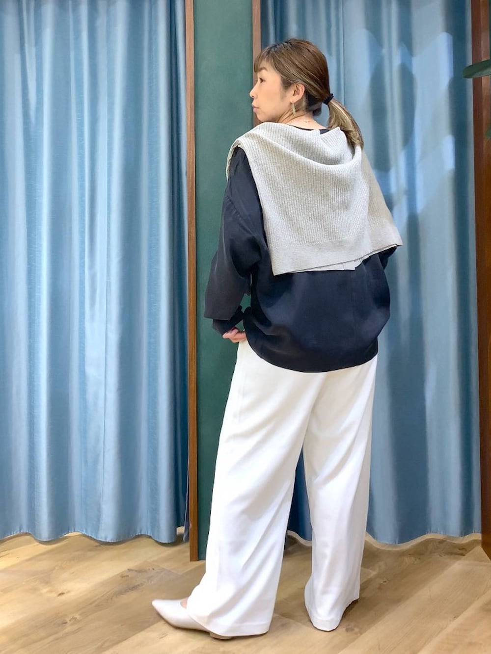 ホワイト系のスラックス、ベージュ系のカーディガン/ボレロ、ホワイト系のパンプスを着用したレディースの冬コーディネートの8枚目の写真