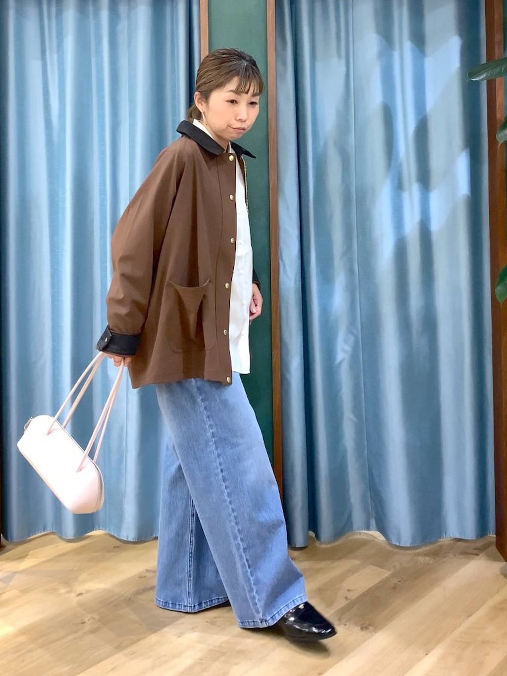 ブルー系のデニムパンツ、ブラウン系のカバーオール、ブラック系のローファーを着用したレディースの冬コーディネートの4枚目の写真