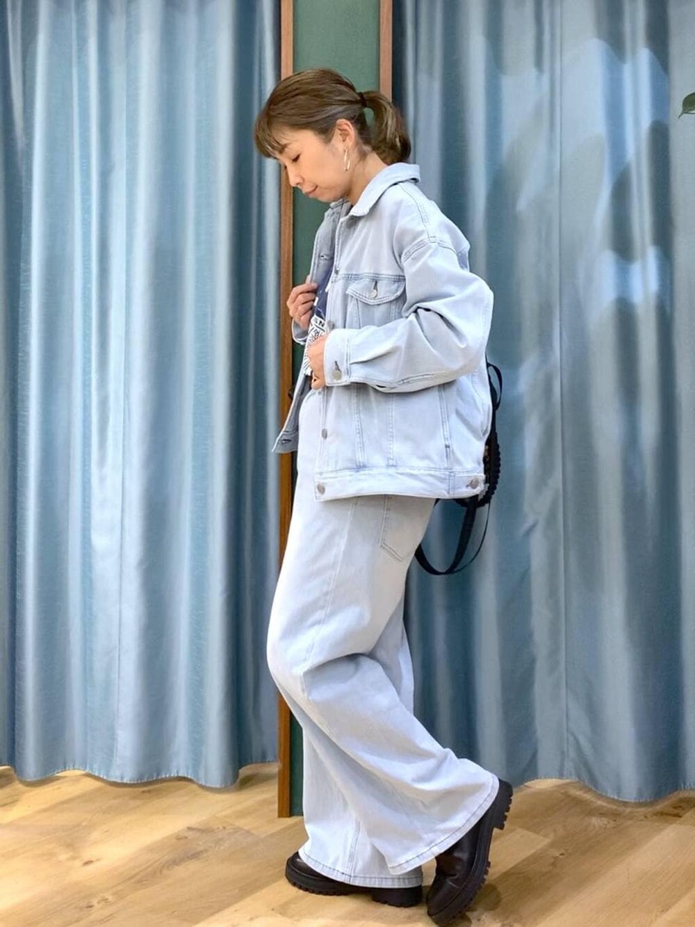 ブラック系のブーツ、ブラック系のバックパック/リュック、ブルー系のデニムパンツを着用したレディースの冬コーディネートの4枚目の写真