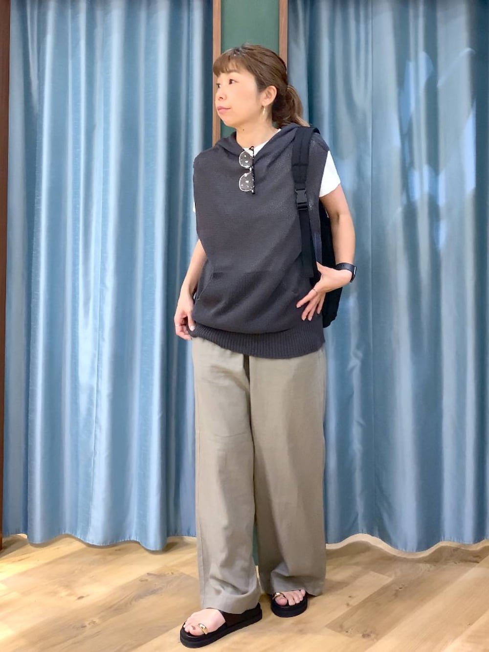 グレー系のニット/セーター、ブラウン系のその他パンツ、ブラック系のサンダルを着用したレディースの春コーディネートの4枚目の写真