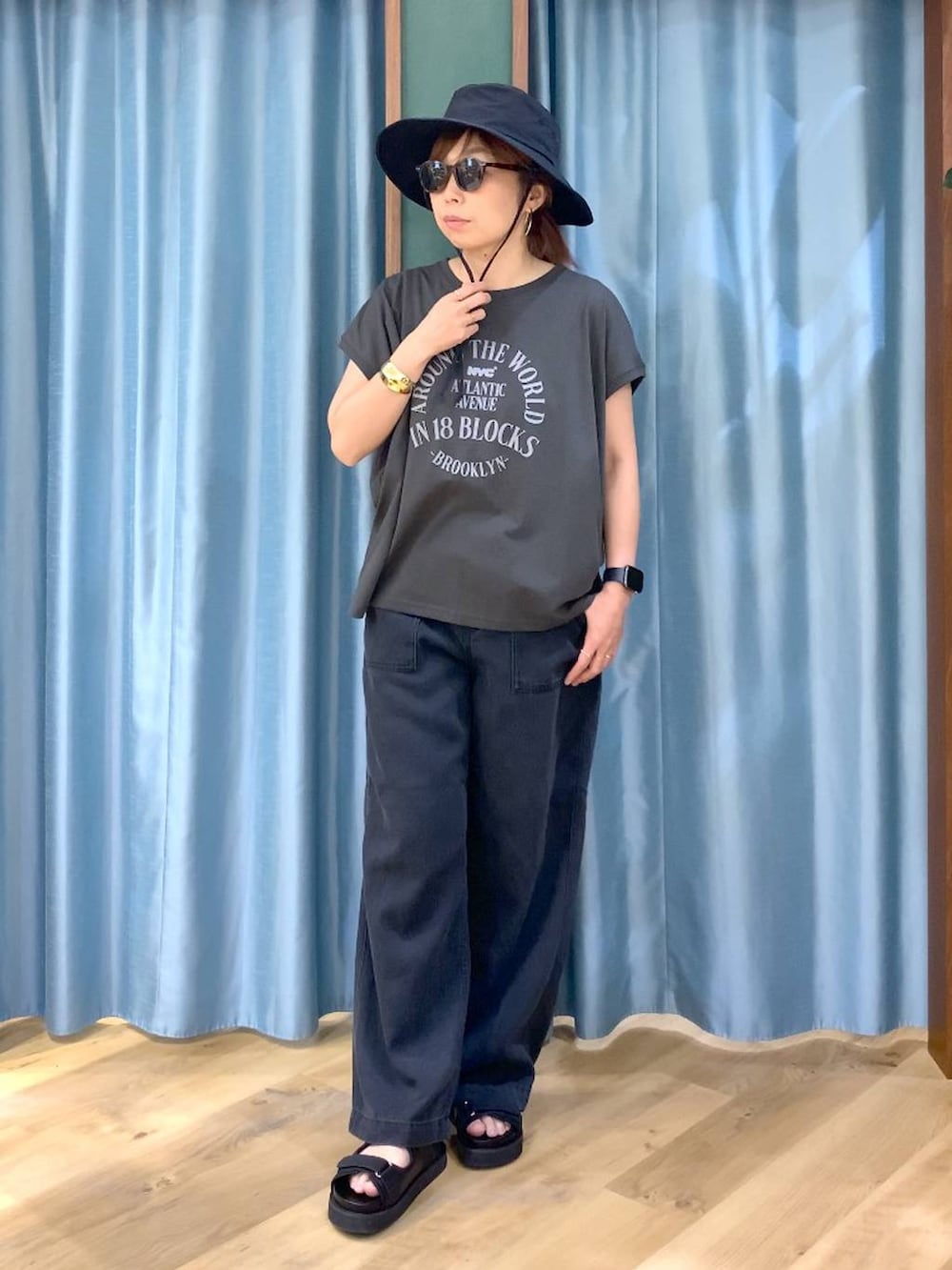 ブラック系のTシャツ/カットソー、グレー系のデニムパンツ、ブラック系のサンダルを着用したレディースの春コーディネートの2枚目の写真