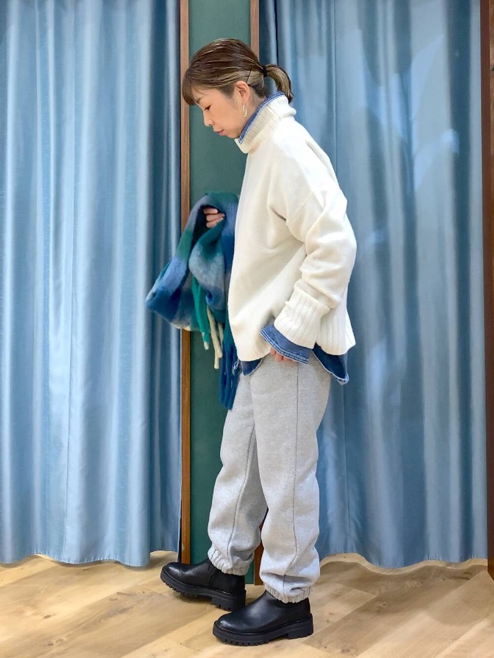 ブラック系のブーツ、ブルー系のシャツ/ブラウス、ホワイト系のニット/セーターを着用したレディースの秋コーディネートの2枚目の写真