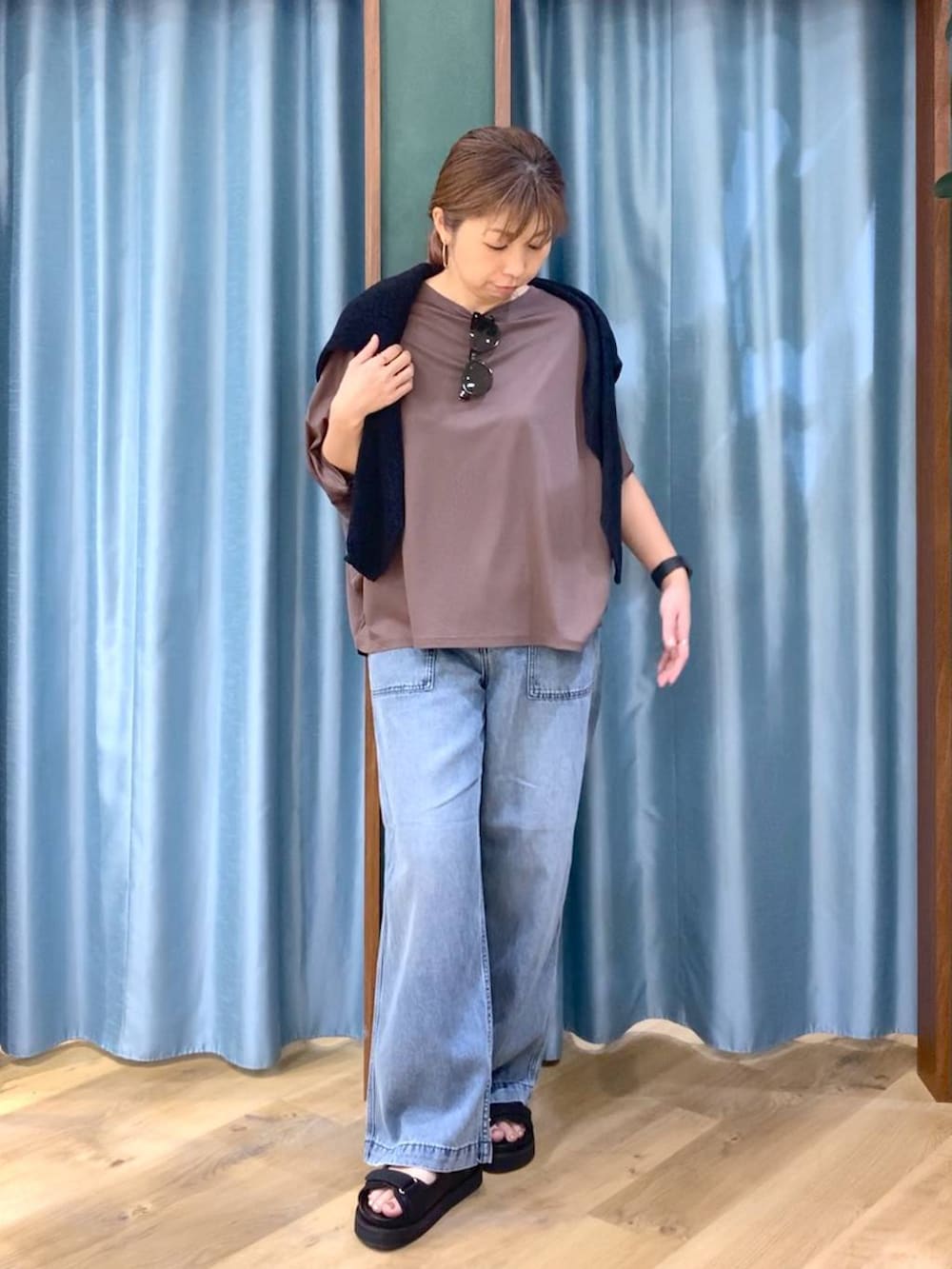 ブラウン系のTシャツ/カットソー、ブルー系のデニムパンツ、ブラック系のニット/セーターを着用したレディースの春コーディネートの3枚目の写真