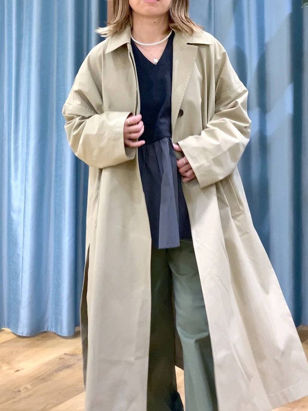 グリーン系のその他パンツ、ベージュ系のステンカラーコート、グレー系のTシャツ/カットソーを着用したレディースの冬コーディネートの7枚目の写真