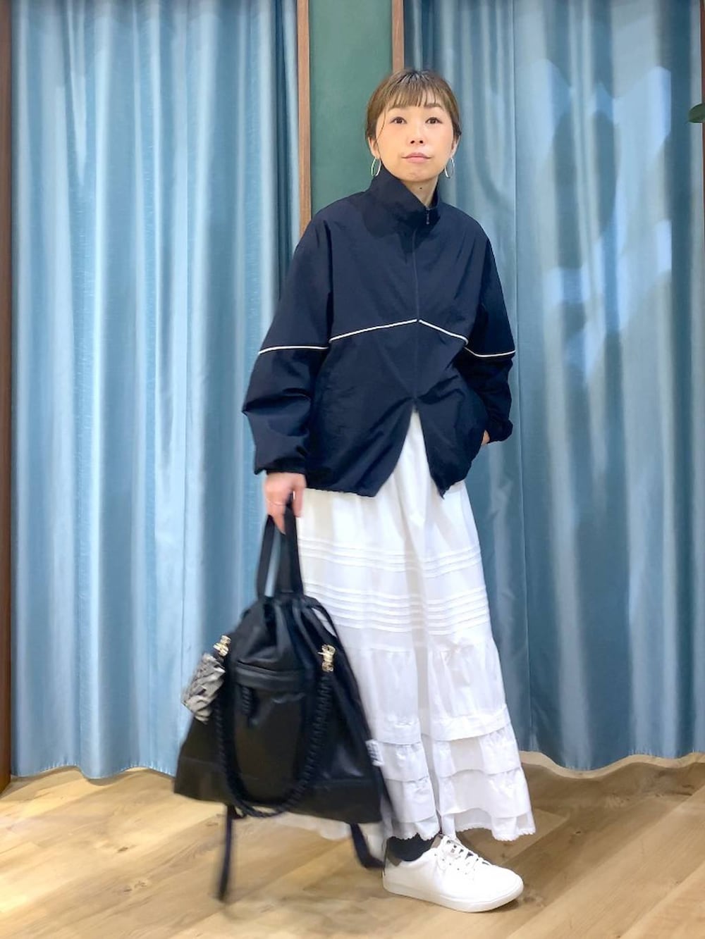 ブラック系のバックパック/リュック、ブルー系のナイロンジャケット、ブラウン系のスニーカーを着用したレディースの冬コーディネートの2枚目の写真