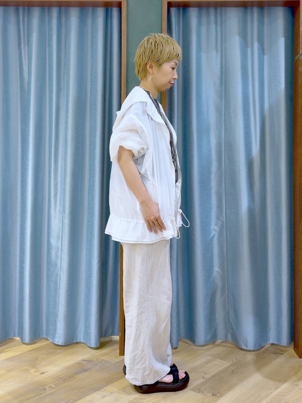 ベージュ系のその他パンツ、ホワイト系のブルゾン、ブラック系のサンダルを着用したレディースの夏コーディネートの2枚目の写真