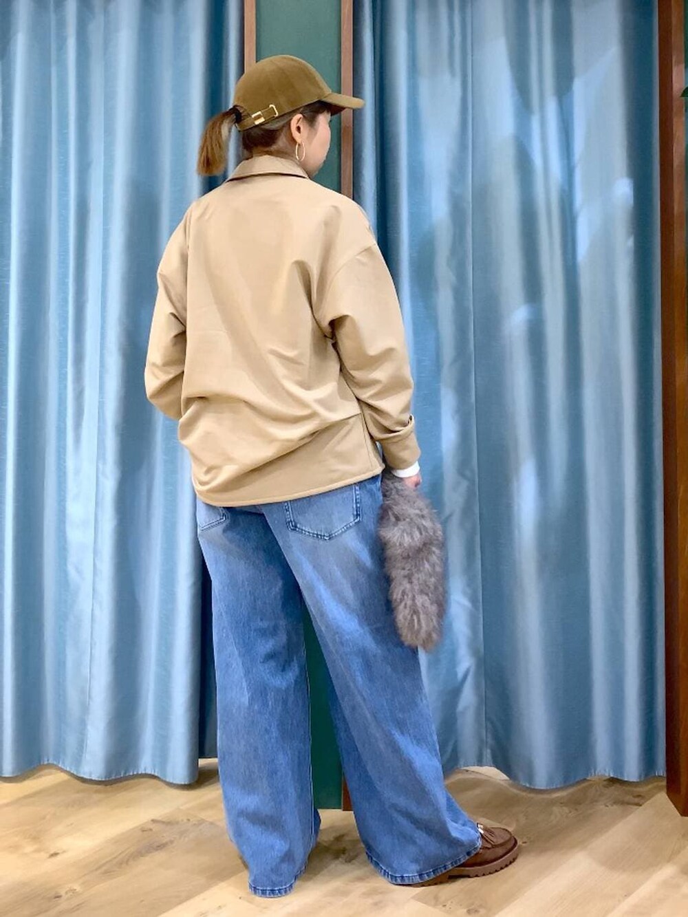 ブルー系のデニムパンツ、ブラウン系のトートバッグ、ブラウン系のローファーを着用したレディースの冬コーディネートの3枚目の写真
