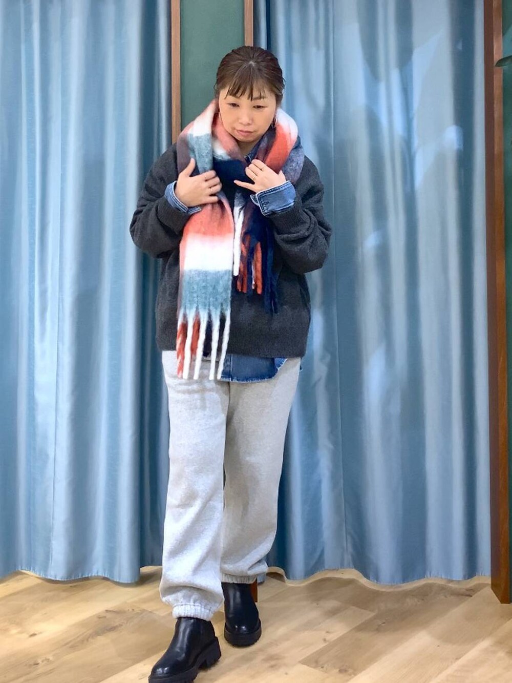 ブラック系のブーツ、ブルー系のシャツ/ブラウス、グレー系のニット/セーターを着用したレディースの秋コーディネートの4枚目の写真