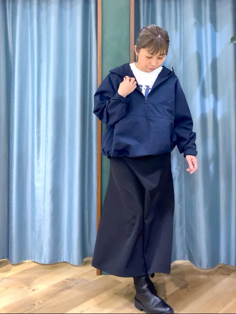 ブラック系のブーツ、ブラック系のスカート、ブルー系のナイロンジャケットを着用したレディースの冬コーディネートの5枚目の写真