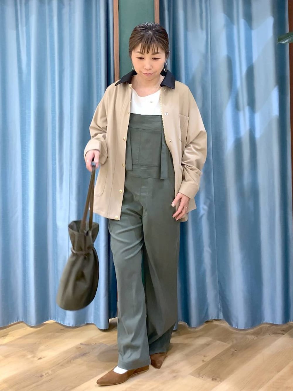 グリーン系のサロペット/オーバーオール、ベージュ系のカバーオール、ホワイト系のTシャツ/カットソーを着用したレディースの冬コーディネートの2枚目の写真