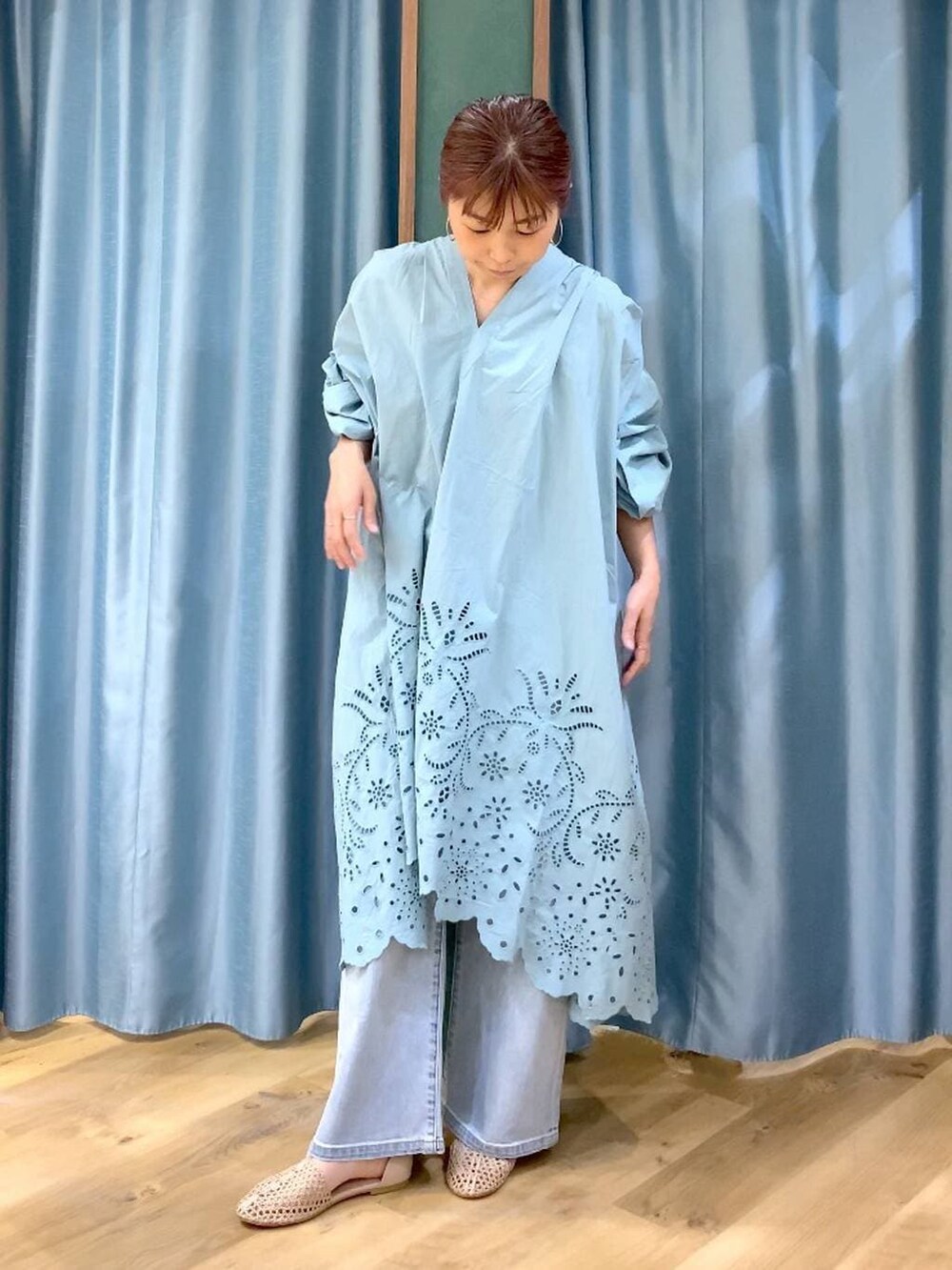 ブルー系のデニムパンツ、ベージュ系のスリッポン、グリーン系のワンピースを着用したレディースの春コーディネートの3枚目の写真