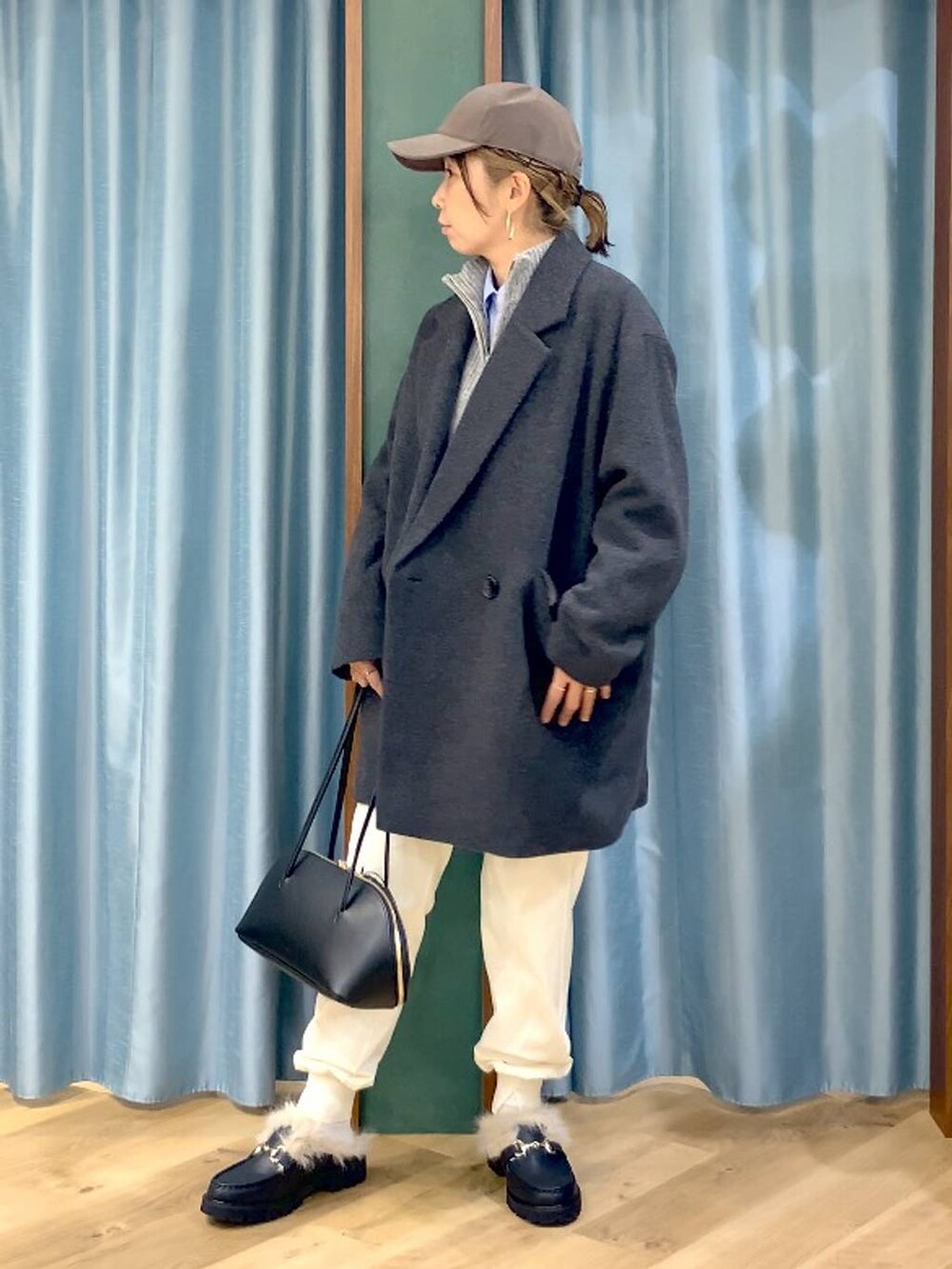 ブラック系のトートバッグ、ブルー系のシャツ/ブラウス、グレー系のベストを着用したレディースの秋コーディネートの4枚目の写真