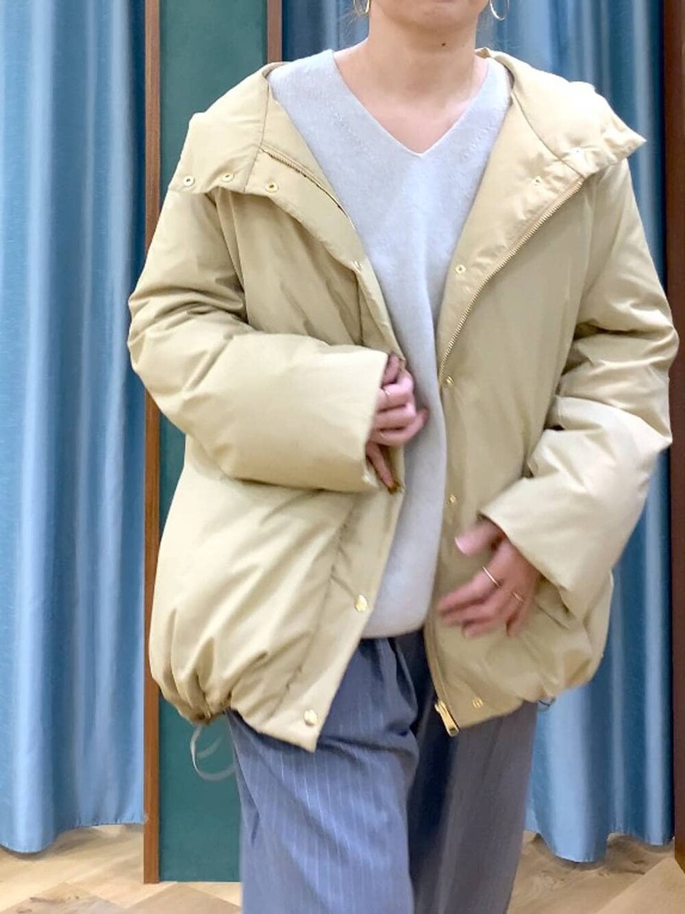 ベージュ系のダウンジャケット/コート、ベージュ系のニット/セーター、ブラック系のブーツを着用したレディースの冬コーディネートの6枚目の写真