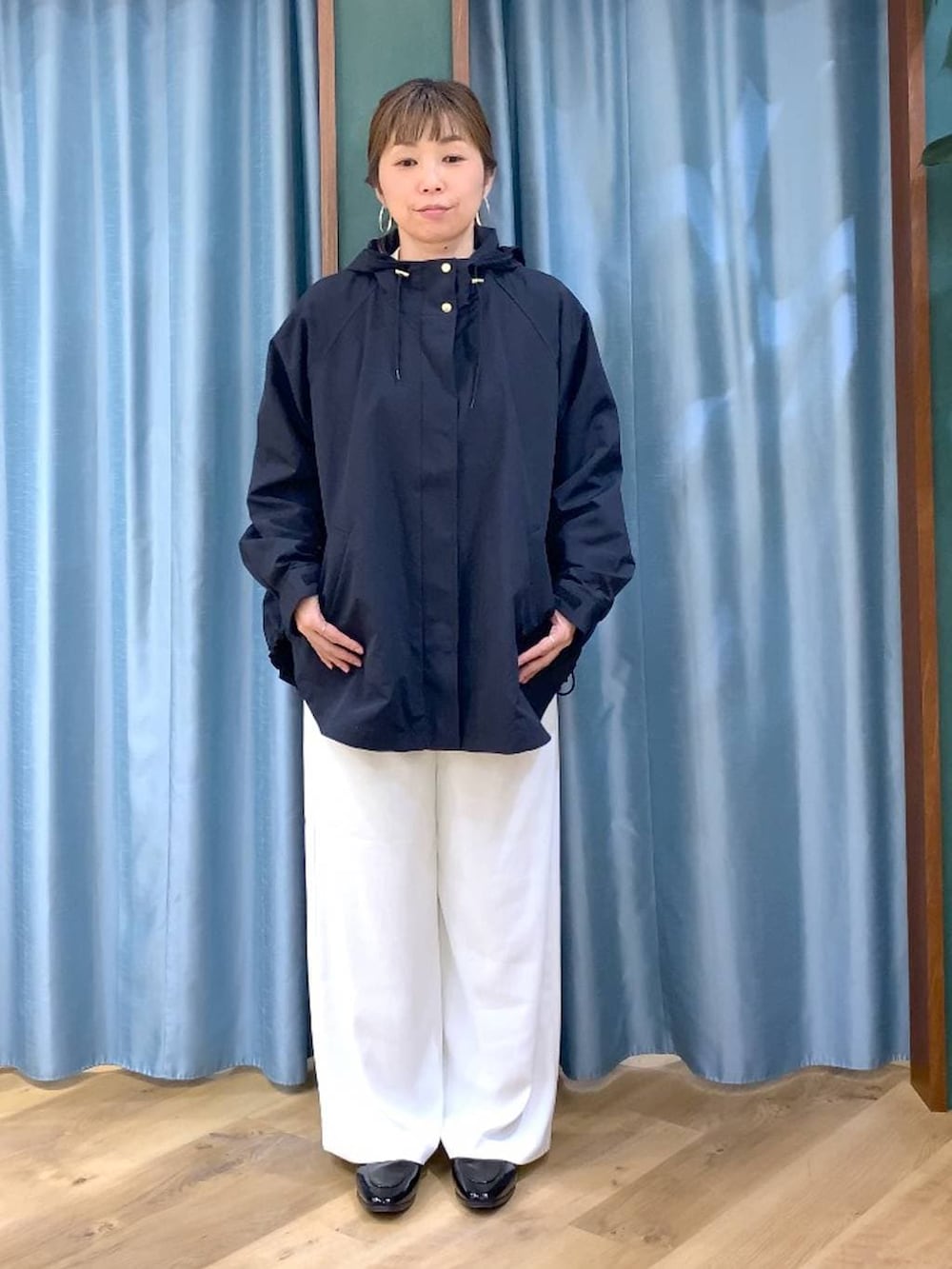 ホワイト系のスラックス、ベージュ系のTシャツ/カットソー、ブラック系のローファーを着用したレディースの春コーディネートの5枚目の写真