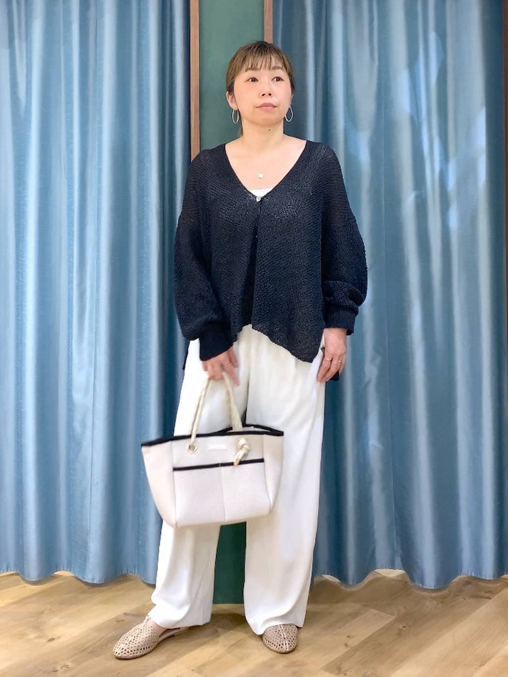 ホワイト系のスラックス、ブラック系のカーディガン/ボレロ、ホワイト系のトートバッグを着用したレディースの春コーディネートの4枚目の写真