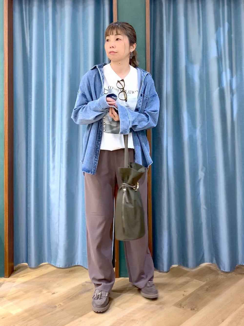 グリーン系のスラックス、ブルー系のシャツ/ブラウス、グレー系のローファーを着用したレディースの春コーディネートの2枚目の写真