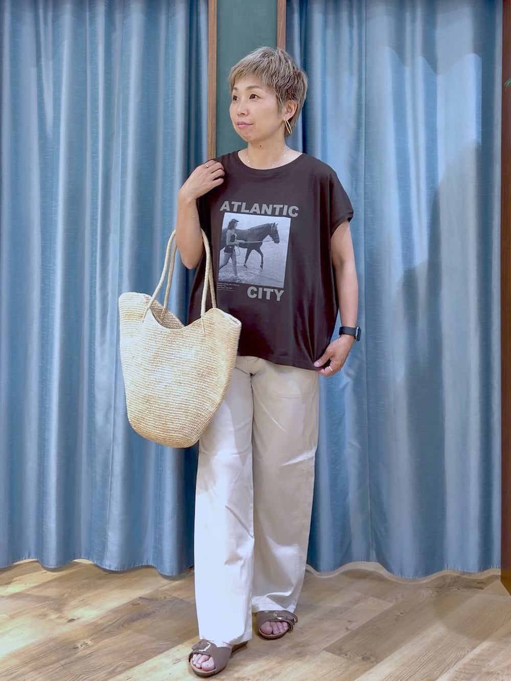 ブラウン系のTシャツ/カットソー、ホワイト系のチノパンツ、ブラウン系のサンダルを着用したレディースの夏コーディネートの2枚目の写真