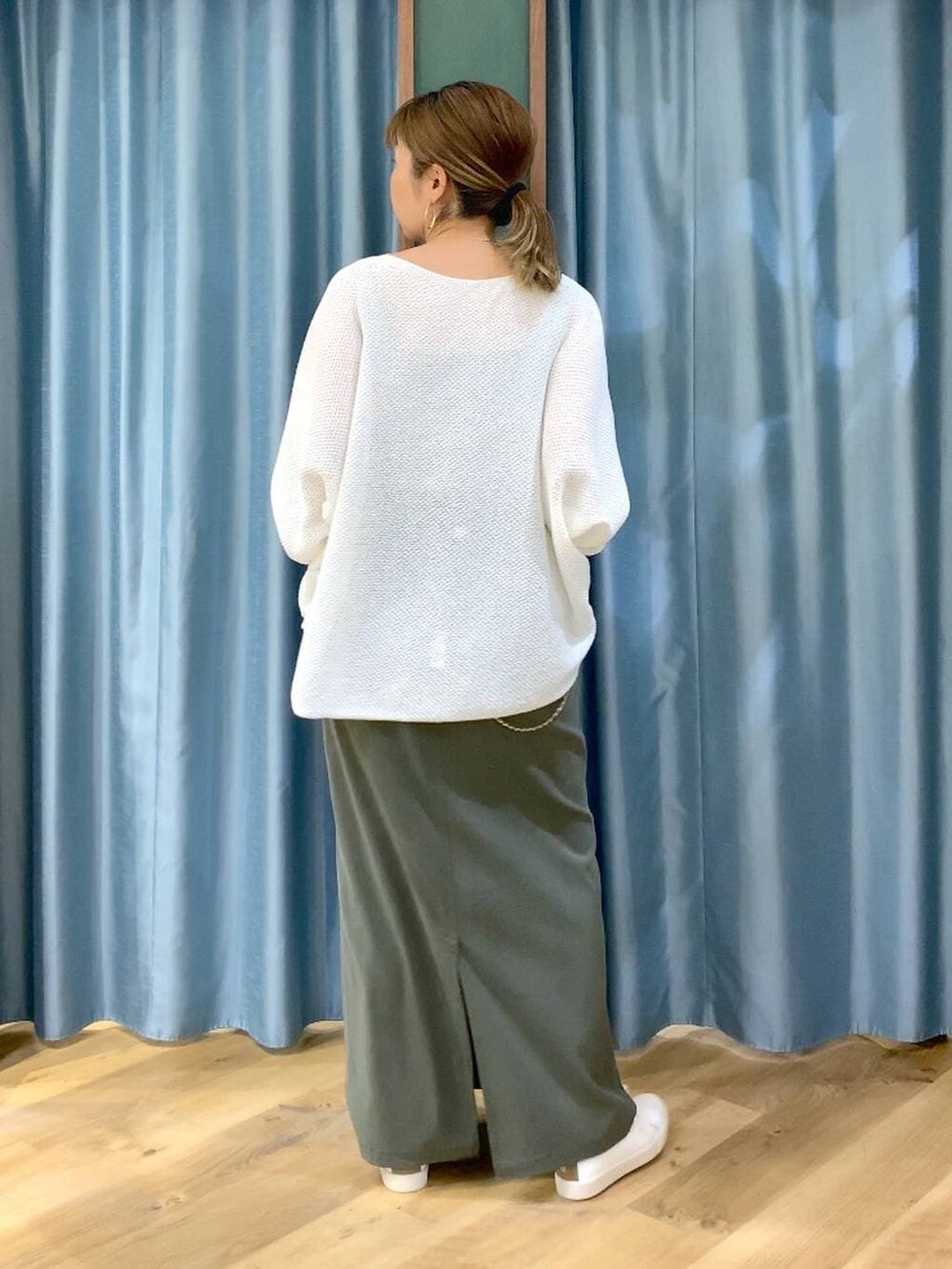 ホワイト系のニット/セーター、グリーン系のスカート、ブラウン系のスニーカーを着用したレディースの春コーディネートの6枚目の写真