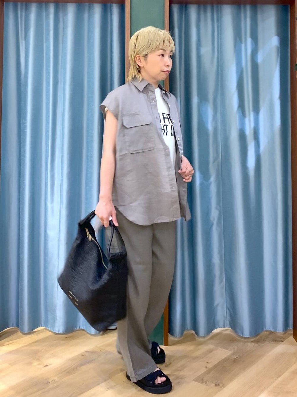 グレー系のその他パンツ、ホワイト系のTシャツ/カットソー、ブラック系のサンダルを着用したレディースの夏コーディネートの3枚目の写真