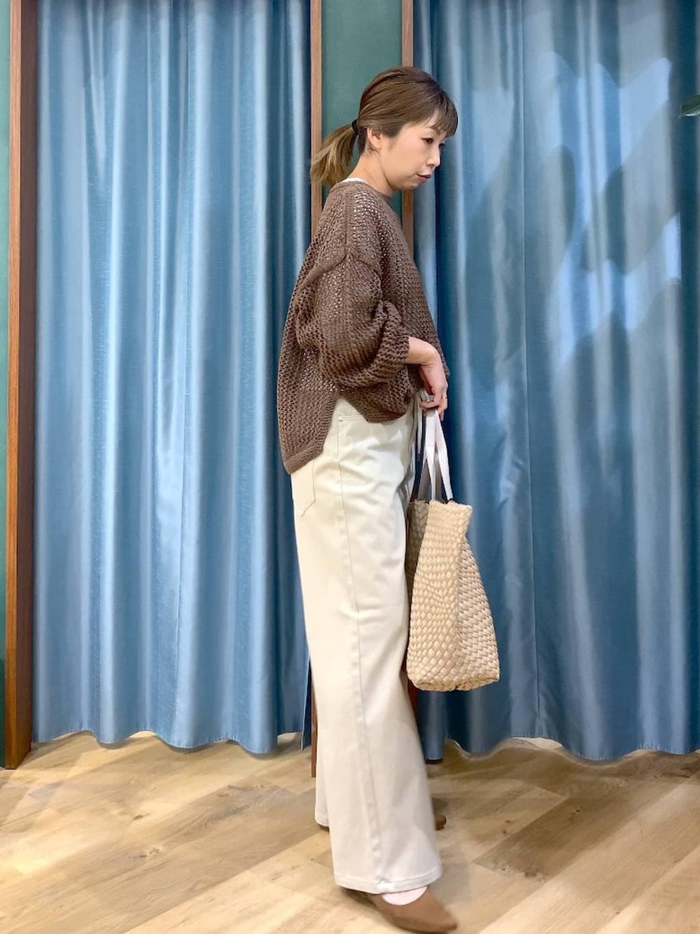 ブラウン系のニット/セーター、ホワイト系のTシャツ/カットソー、ベージュ系のデニムパンツを着用したレディースの冬コーディネートの5枚目の写真