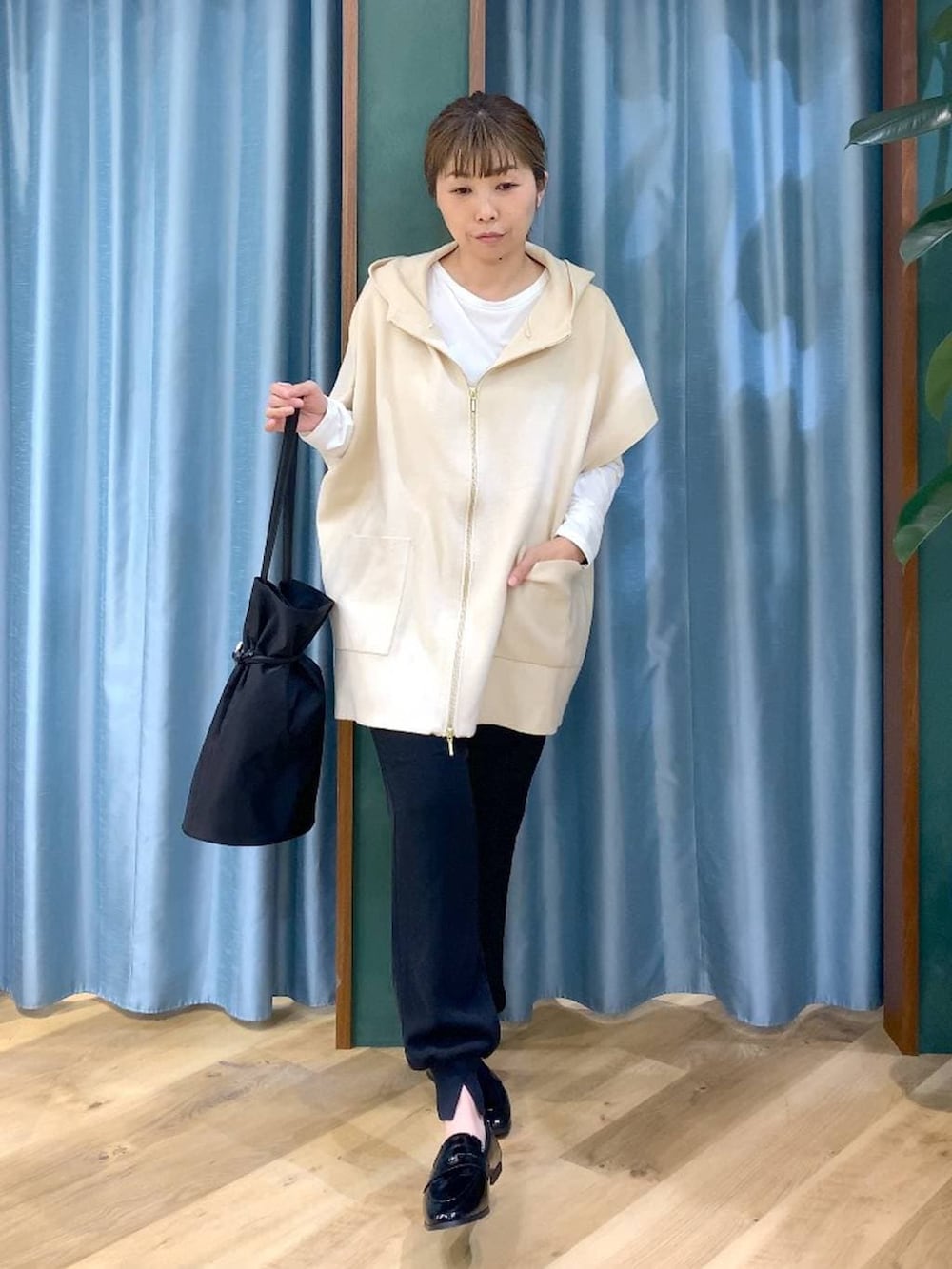 ホワイト系のベスト、ホワイト系のTシャツ/カットソー、ブラック系のその他パンツを着用したレディースの冬コーディネートの2枚目の写真