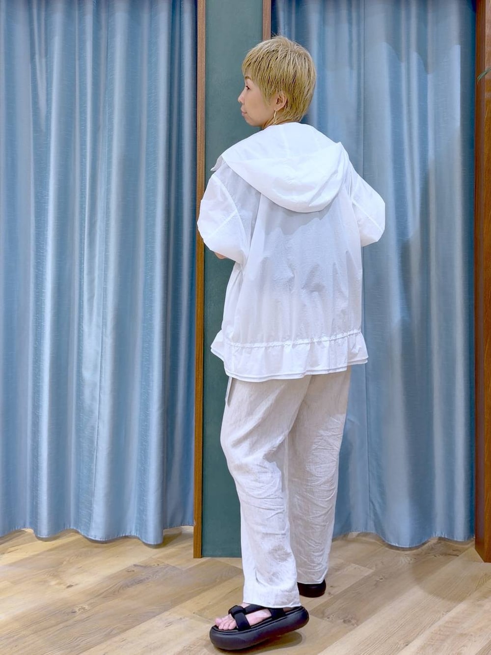 ベージュ系のその他パンツ、ホワイト系のブルゾン、ブラック系のサンダルを着用したレディースの夏コーディネートの3枚目の写真