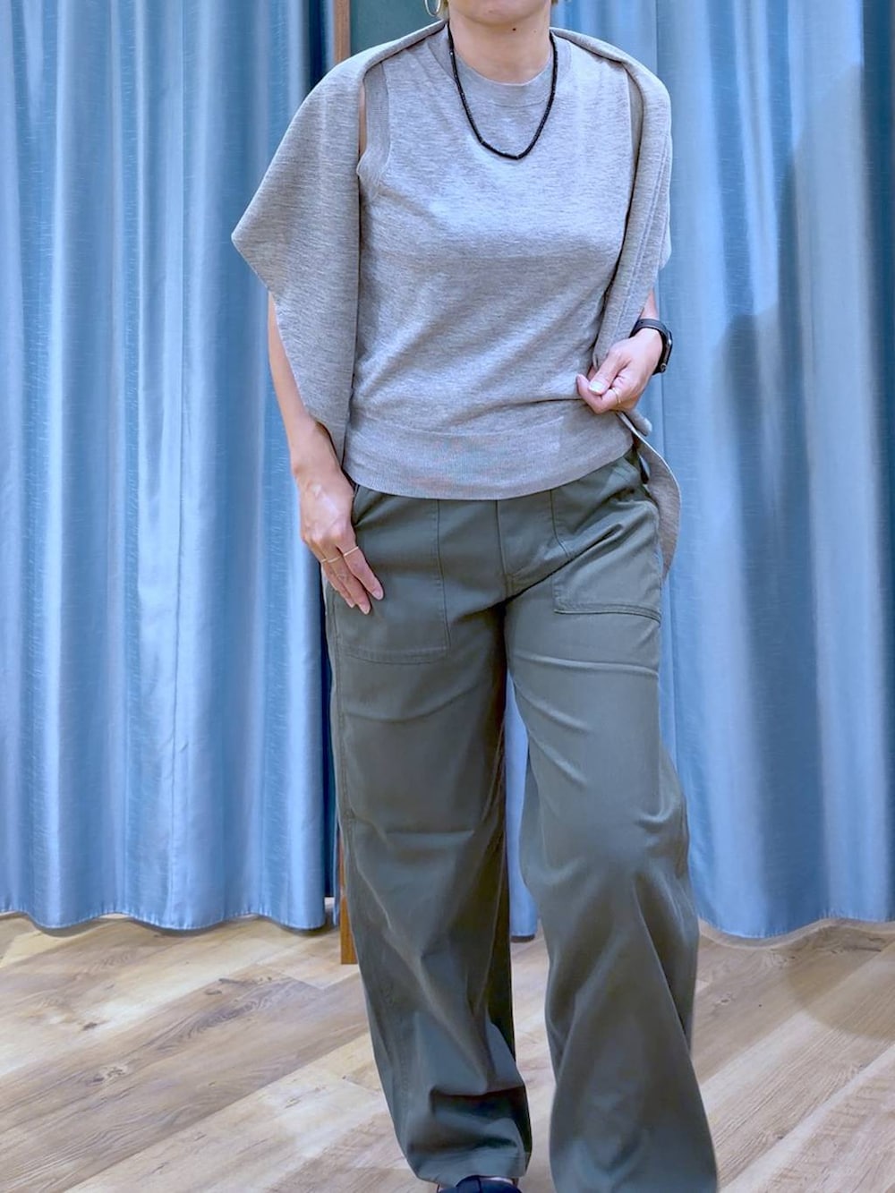 グリーン系のチノパンツ、ブラック系のサンダル、グレー系のニット/セーターを着用したレディースの夏コーディネートの6枚目の写真
