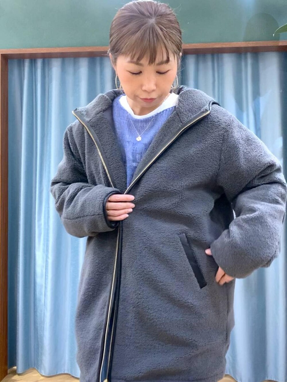 ブラック系のブーツ、ブルー系のデニムパンツ、ブルー系のニット/セーターを着用したレディースの冬コーディネートの6枚目の写真