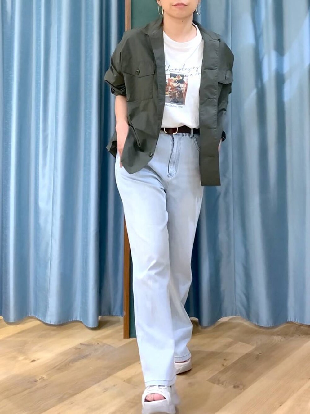 ブルー系のデニムパンツ、ホワイト系のTシャツ/カットソー、グレー系のサンダルを着用したレディースの春コーディネートの7枚目の写真