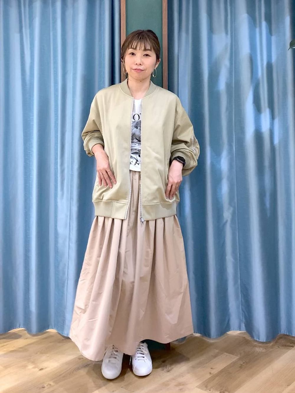 ブラウン系のショルダーバッグ、ベージュ系のスカート、ベージュ系のMA-1を着用したレディースの冬コーディネートの8枚目の写真