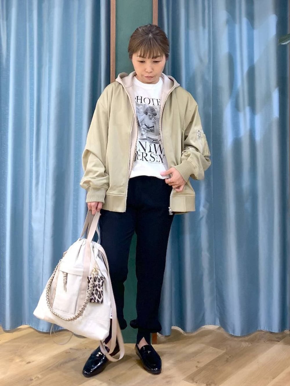 ベージュ系のパーカー、グリーン系のMA-1、ホワイト系のTシャツ/カットソーを着用したレディースの冬コーディネートの3枚目の写真