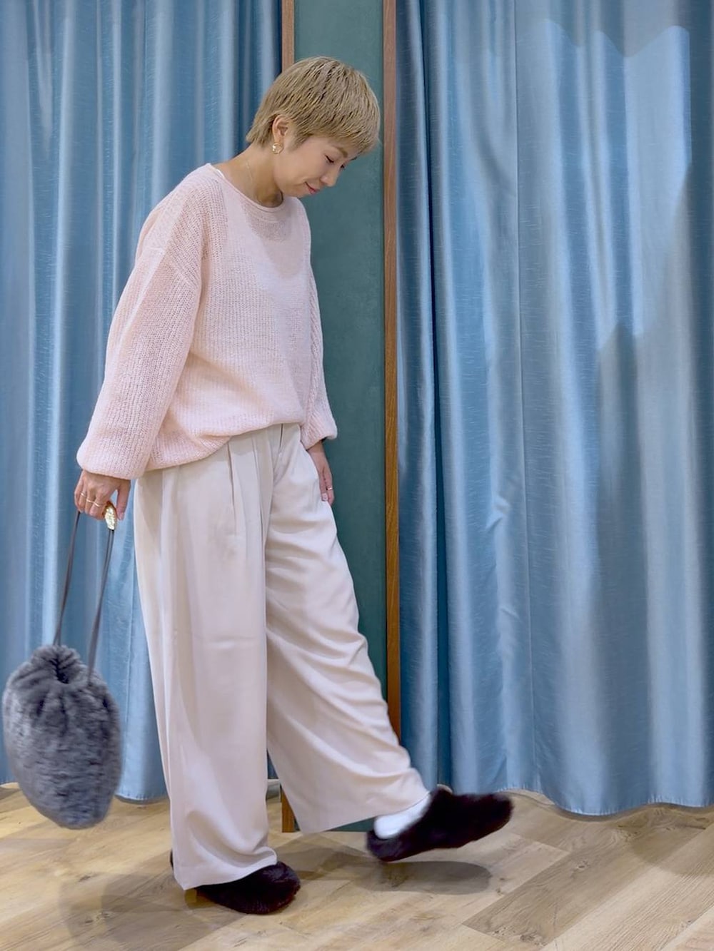 グレー系のハンドバッグ、ブラウン系のその他シューズ、ピンク系のスラックスを着用したレディースの秋コーディネートの4枚目の写真
