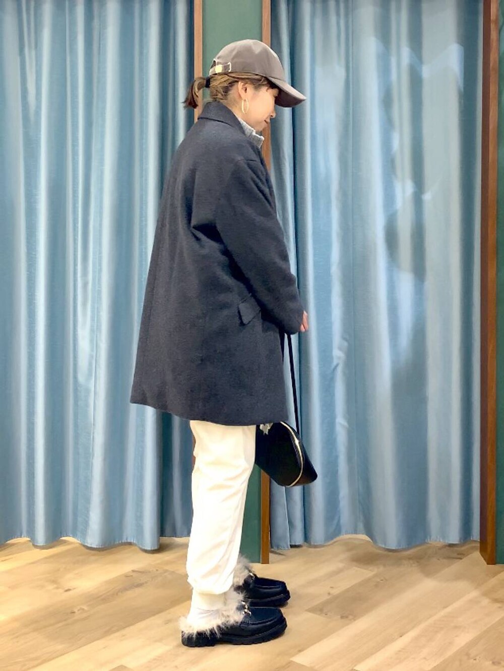 ブラック系のトートバッグ、ブルー系のシャツ/ブラウス、グレー系のベストを着用したレディースの秋コーディネートの3枚目の写真