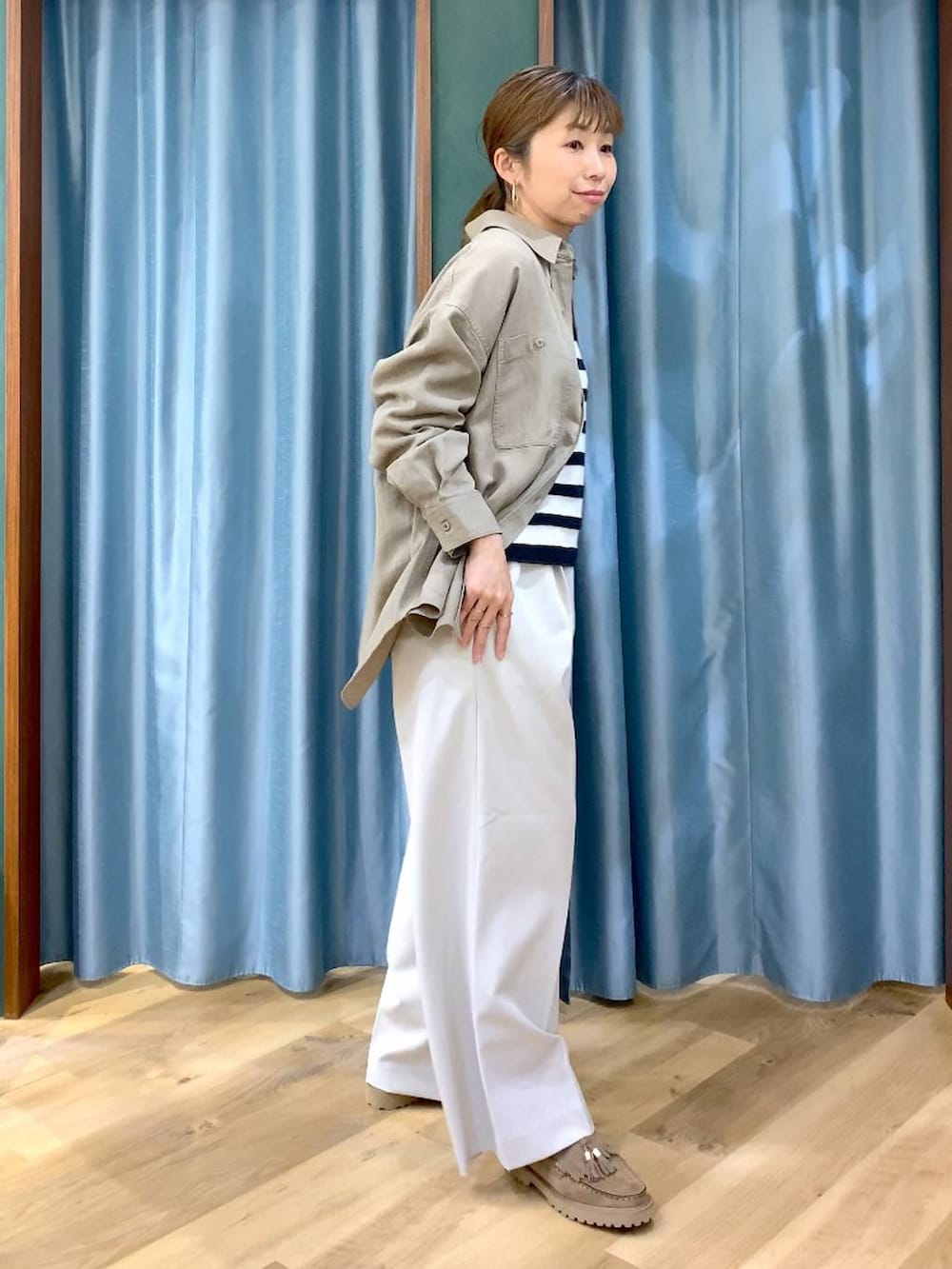 ベージュ系のローファー、グリーン系のシャツ/ブラウス、ベージュ系のニット/セーターを着用したレディースの春コーディネートの4枚目の写真