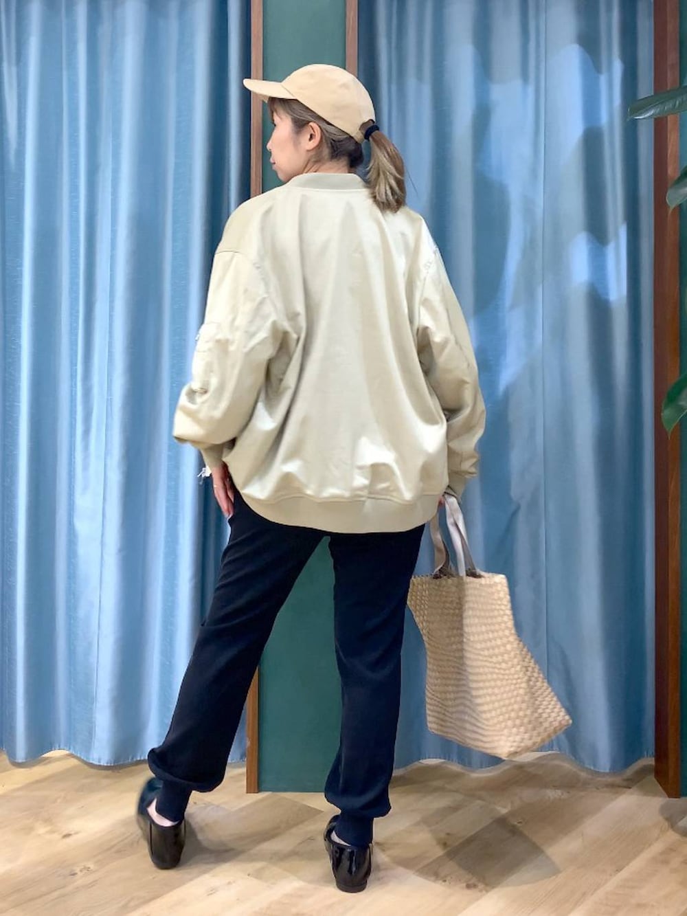 ベージュ系のMA-1、ブラック系のTシャツ/カットソー、ベージュ系のトートバッグを着用したレディースの冬コーディネートの5枚目の写真